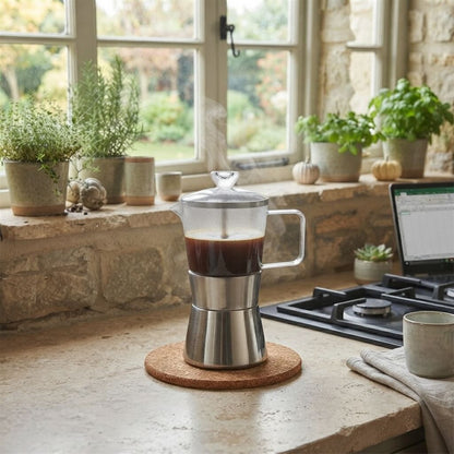 Cafetière à l'italienne en verre et acier inoxydable déposée sur un comptoir en pierre