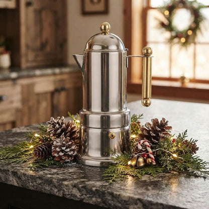 Cafetière italienne induction L'Élégante déposée sur comptoir de granit entourée d'une décoration de Noël