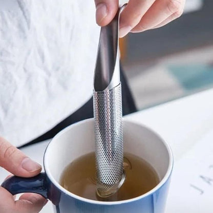 Gros plan sur Cuillère à thé | Élégance Inox - de forme cylindrique en maille d'acier, biseautée, plongée directement dans tasse d'eau chaude bleue et blanche