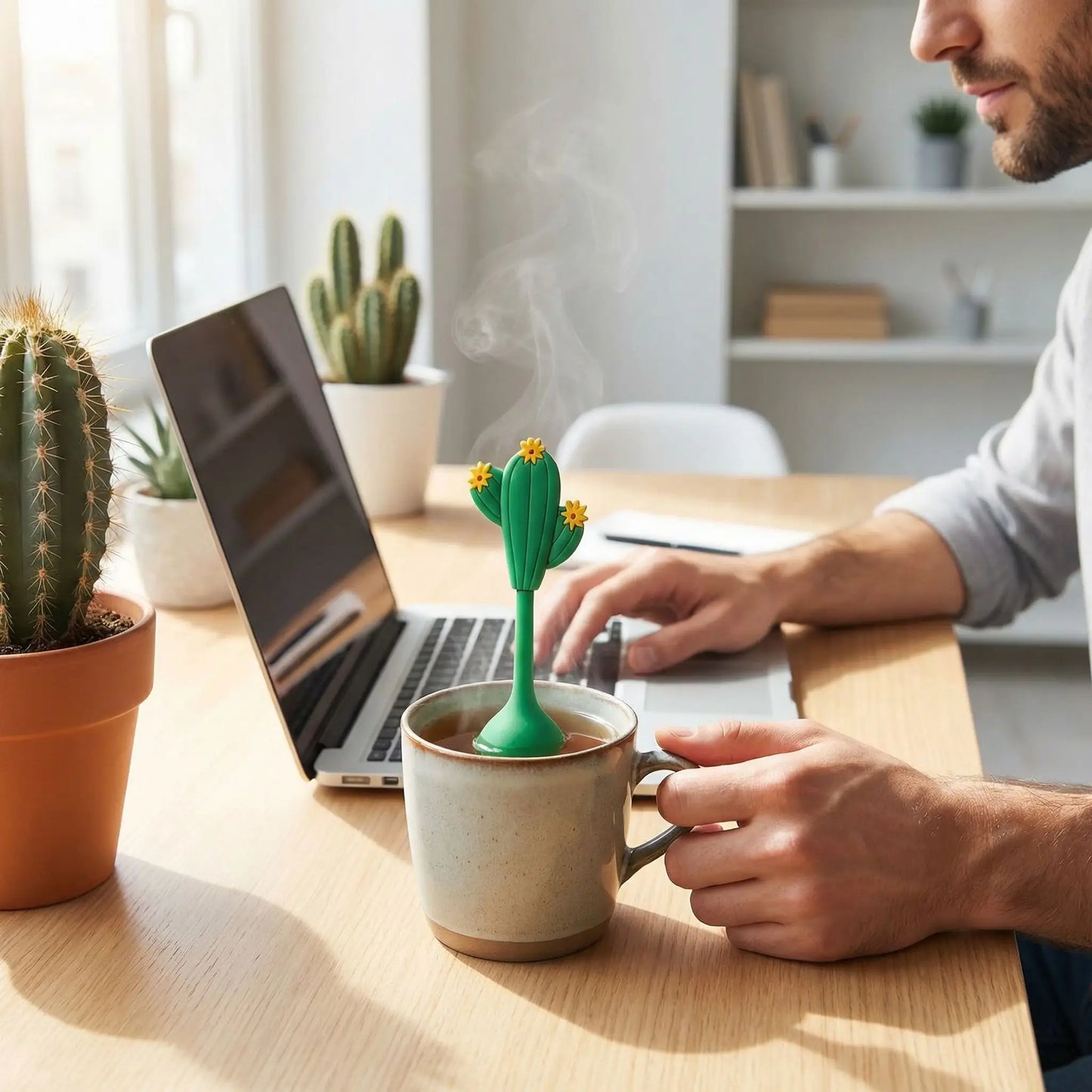 Homme entrain de travailler avec son portable en dégustant une tisane faite avec son Infuseur à Thé |Couleurs d'Été en forme de cactus