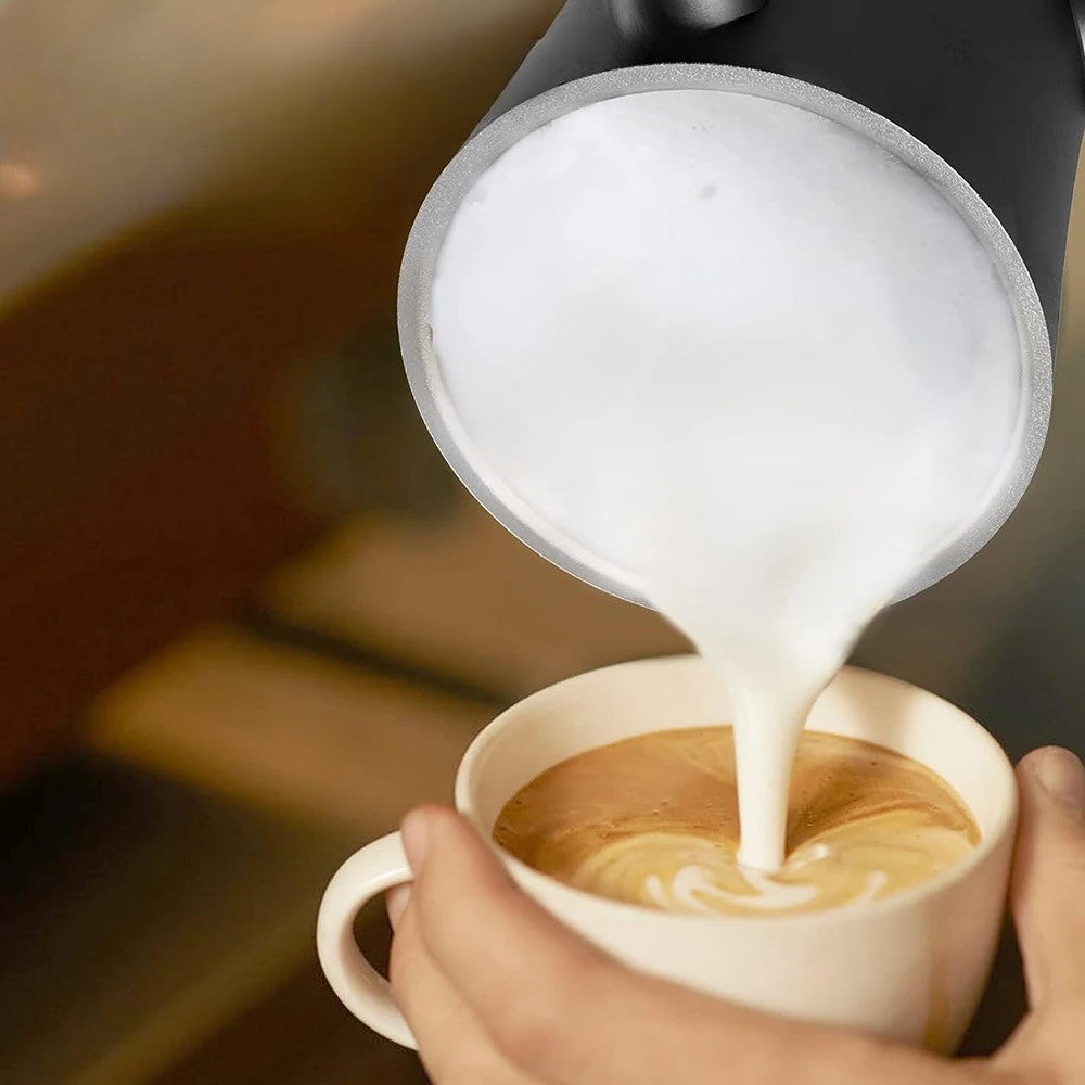 Mousse de lait onctueuse versée depuis le Mousseur à lait électrique | Mousséat dans tasse de café.