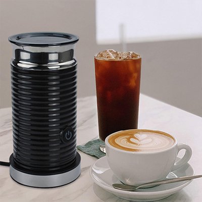 Mousseur à lait électrique élégant présenté sur une table en bois entre un café latte chaud et un grand café glacé rafraîchissant.
