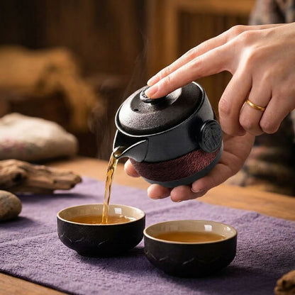 Service à thé Pulsar Noir femme versant infusion dans tasses de l'ensemble